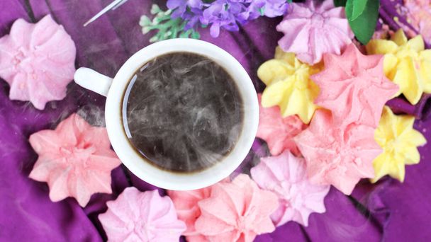 Meringhe colorate e una tazza di caffè, sfondo viola - Foto, immagini