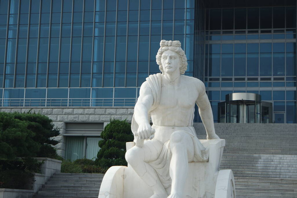 ЧУНЧОН, ЮЖНАЯ КОРЕЯ - 3 октября 2020 года: Беломраморная каменная статуя сидящего Посейдона или Нептуна - Фото, изображение