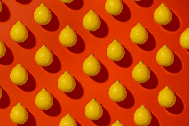 Patterns with fresh lemon on a orange background. Top view. - Фото, изображение