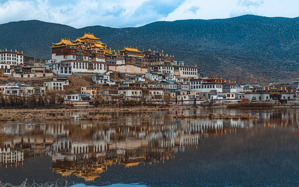 Reflectie van het Ganden Sumtseling klooster - Foto, afbeelding