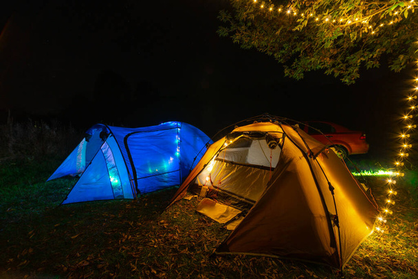 Turist kamp çadırları. Işıkları açın. Vahşi bir yerde bir gece. Ceset yok. Aktif yaşam tarzı konsepti ve eğlence ve yürüyüş ekipmanları. Geniş açı. Mavi ve kahverengi - Fotoğraf, Görsel