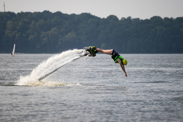 Nuori tyttö jet saappaat hyppää järveen - hydroflying. - Valokuva, kuva