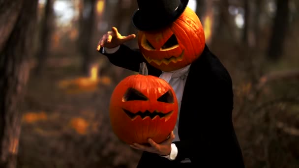 Gruseliger Mann mit Kürbisköpfen führt einen Halloween-Trick mit Rauch im Wald vor - Filmmaterial, Video