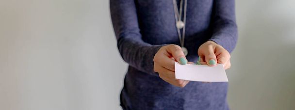 Бизнесмен показывает чистую открытку. Профессиональная женщина, держащая белую визитную карточку - Фото, изображение