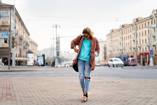 Young beautiful woman with hair walks in the autumn city. Urban  - Fotó, kép