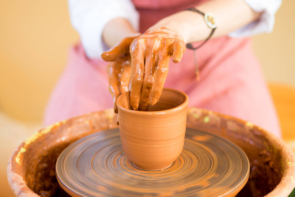 La mujer esculpe la taza de la olla de barro. Taller de modelado sobre rueda de alfarero. - Foto, Imagen