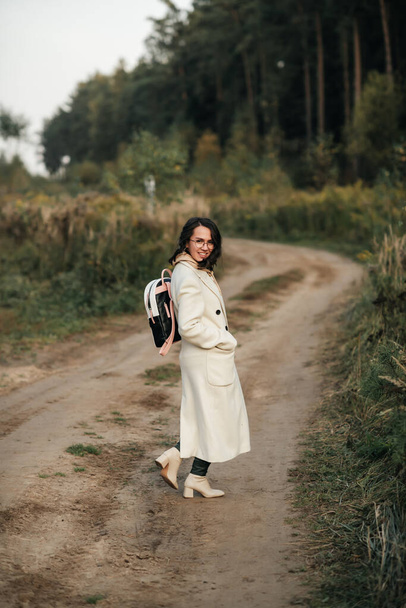 brunette girl with backpack on the forest path - Fotografie, Obrázek