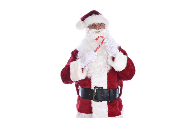 Старший чоловік у традиційному костюмі Санта Клауса, який тримає цукерку в обох руках. Ізольовані на білому. - Фото, зображення