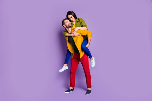 Full body photo pretty lady handsome guy couple carry piggyback meet adventures playful mood spend time quarantine wear casual bright shirts pants outfit isolated purple color background - Photo, image