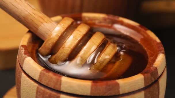 palo de madera para tazón con miel fresca floral líquida. Goteo de miel orgánica saludable, vertido de cuchara de madera de miel. - Imágenes, Vídeo