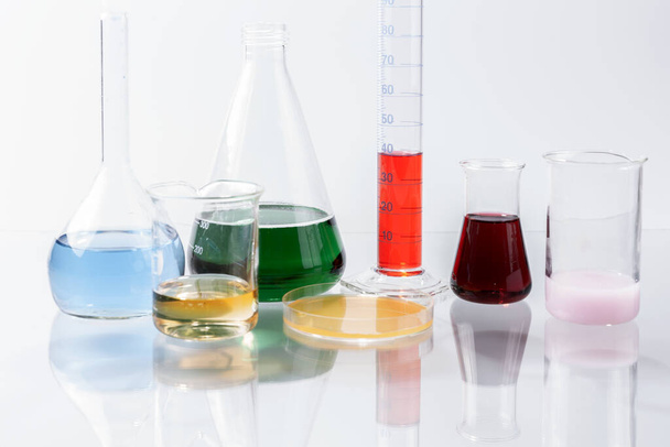 Aparato de laboratorio de vidrio con agua de color en la mesa de vidrio - Foto, Imagen