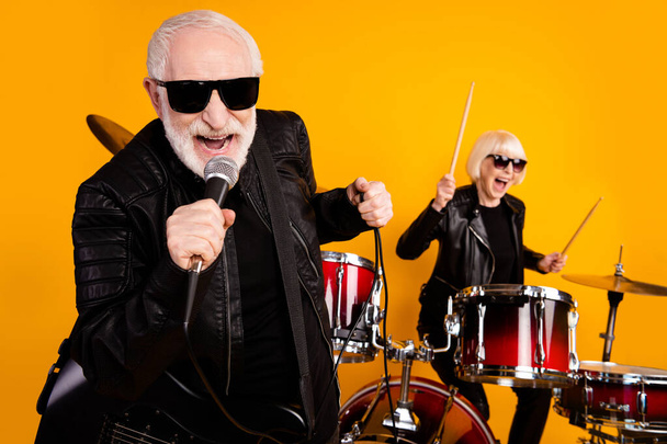 Close-up portrait of nice attractive cheerful cheery grey-haired couple musician performing live famous hit single genre young soul isolated over bright vivid shine vibrant yellow color background - Fotografie, Obrázek