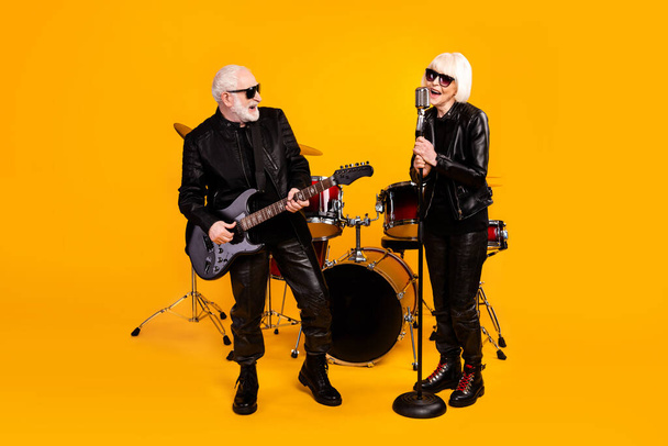 Portrait of his he her she nice attractive cheerful cheery grey-haired couple friends musicians performing singing live hit isolated over bright vivid shine vibrant yellow color background - Photo, Image