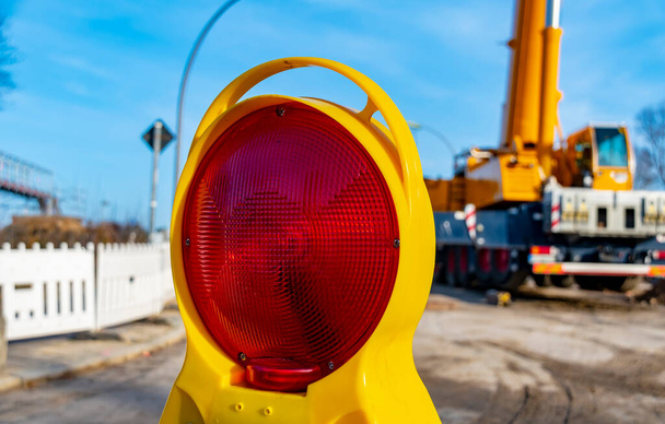 Equipment of a construction site, on which the new railway line for the "Dresden railway" is built, with a red warning lamp in focus. - Photo, Image