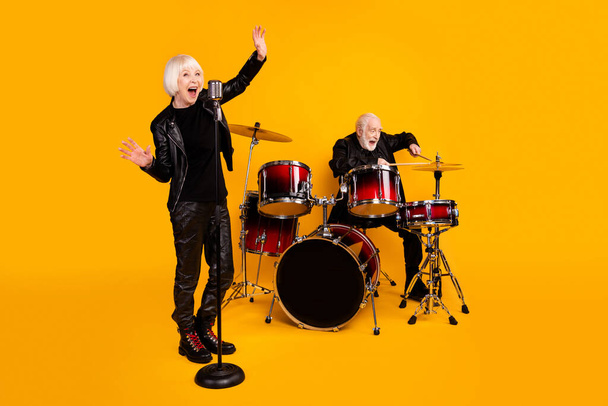 Portrait of his he her she nice attractive cheerful cheery glad excited grey-haired couple performing singing playing live sound isolated over bright vivid shine vibrant yellow color background - Valokuva, kuva