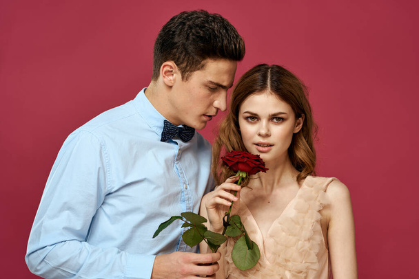 retrato de pareja romántica enamorada de rosa roja sobre fondo aislado y traje clásico vestido de noche - Foto, Imagen