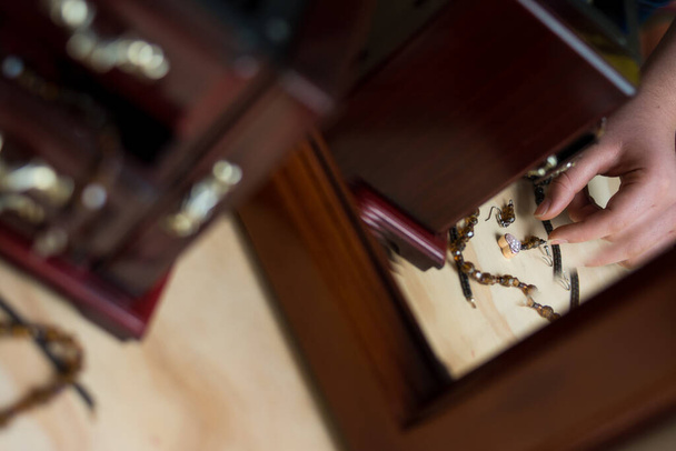 Yatak odasındaki bir masada mücevher taşıyan eski ahşap kuyumcu.   - Fotoğraf, Görsel