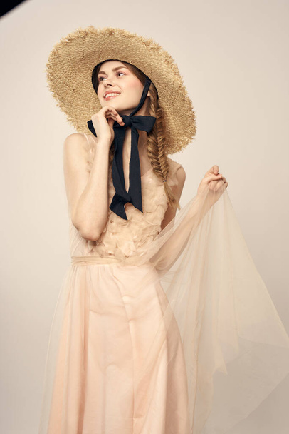 romantique fille en robe beige et en chapeau de paille avec ruban noir émotions portrait de modèle vue recadrée - Photo, image