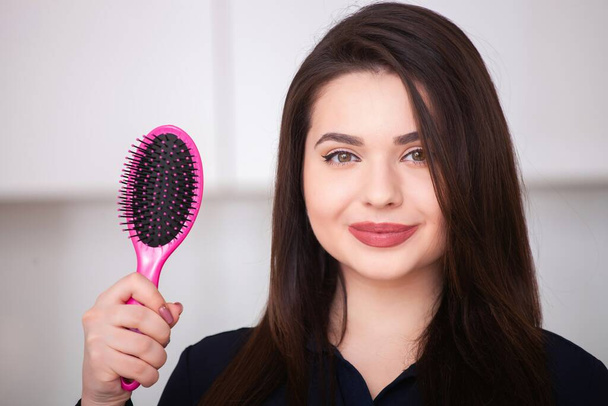 Girl holds a hairbrush  - Fotografie, Obrázek