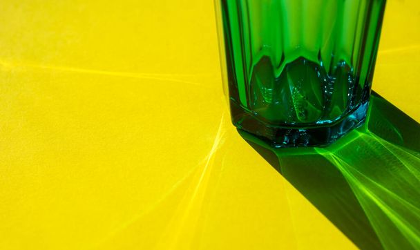 Glass with water on yellow background. selective focus. concept of light refraction. - Photo, image
