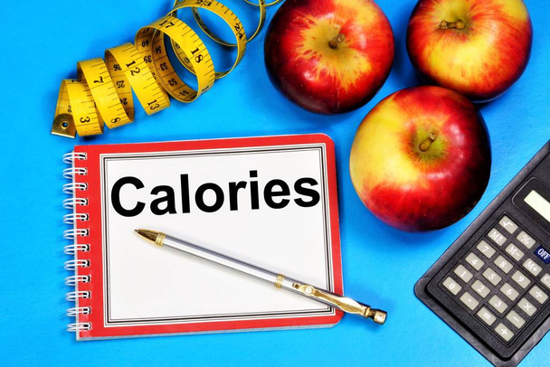Kalorie napis tekstu w Notatniku, planowanie diety. Zdrowy styl życia, zasady obliczania odżywiania.  - Zdjęcie, obraz