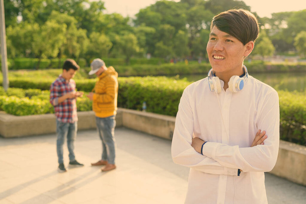 Tre giovani uomini asiatici rilassarsi al parco insieme - Foto, immagini