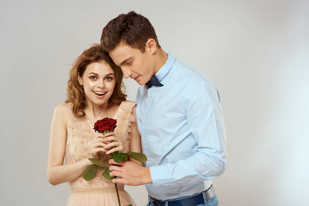 lovers men and woman hugs romance love red rose light background - Фото, изображение