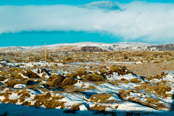 Winter landscape in Iceland. A field of solidified lava covered with moss is covered with snow - Foto, immagini