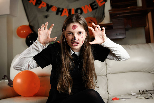 Uma menina com maquiagem Halloween de Santa Muerte ou açúcar crânio mexicano, no dia dos mortos. a menina faz um rosto assustador - Foto, Imagem