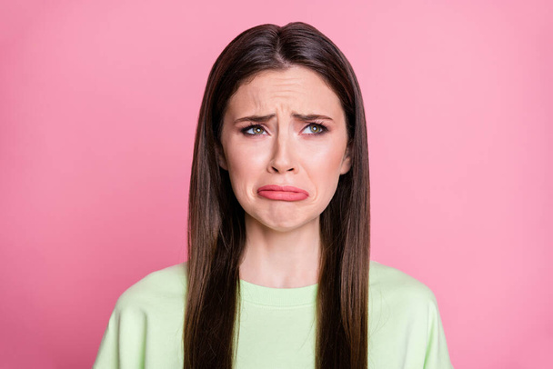 Closeup photo of depressed lady straight long hairdo look moody disappointed empty space crying desperate wear casual green sweatshirt pullover isolated pink pastel color background - Foto, Imagem