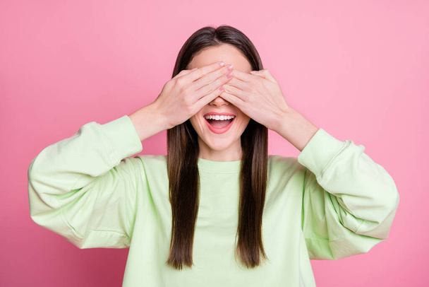 Closeup photo of attractive funny lady straight long hairdo good mood closing eyes arms playing hide-and-seek wear casual green sweatshirt pullover isolated pink pastel color background - Foto, afbeelding