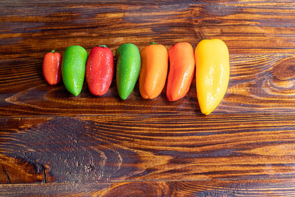 Pimentos multicoloridos búlgaros em uma tábua de madeira. Comida saudável, vitaminas. Espaço de cópia. - Foto, Imagem