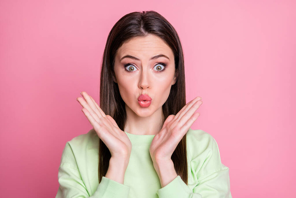 Closeup photo of attractive funny shocked lady straight long hairdo listen amazing good news raise arms wear casual green sweatshirt pullover isolated pink pastel color background - 写真・画像