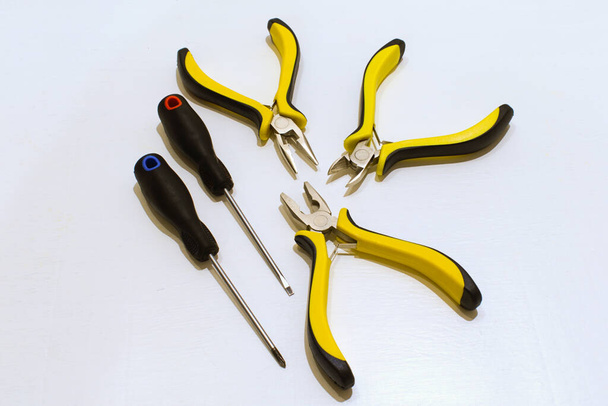 chaves de fenda e ferramentas para trabalho elétrico de perto em um fundo branco - Foto, Imagem