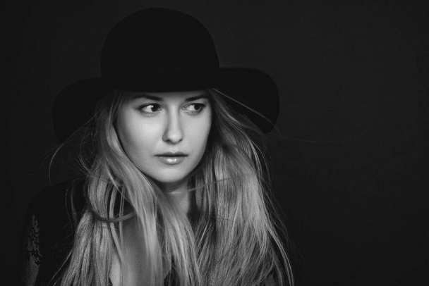 Mooie blonde vrouw draagt een hoed, artistieke film portret in zwart-wit voor mode campagne en schoonheid merk - Foto, afbeelding