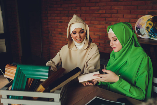 Young muslim asian female designer using graphics tablet while working with computer at studio or office. - Фото, зображення