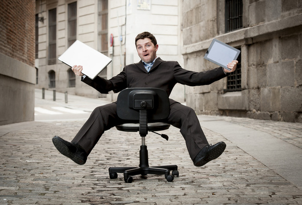  επιχειρηματίας που κυλά προς τα κάτω σε καρέκλα με υπολογιστή και tablet - Φωτογραφία, εικόνα