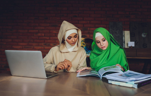 Young muslim asian female designer using graphics tablet while working with computer at studio or office. - Фото, зображення