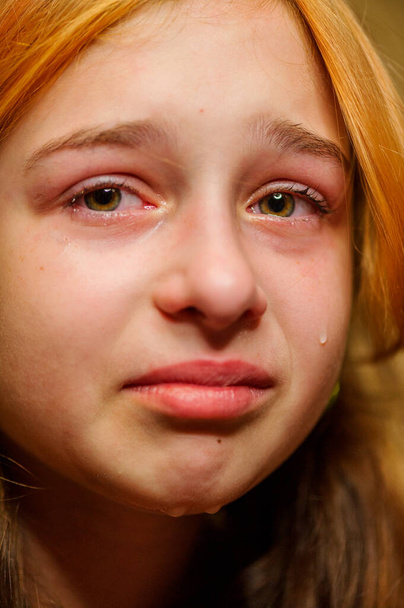 Portret van een huilend meisje met tranen over haar wangen. Een huilend meisje. Meisje van negen is erg van streek. Tienerproblemen. Negen of tien jaar oud meisje in transitie. Verdriet. - Foto, afbeelding