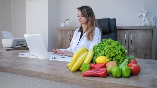 Lekarz dietetyk pracujący w jej biurze - Zdjęcie, obraz