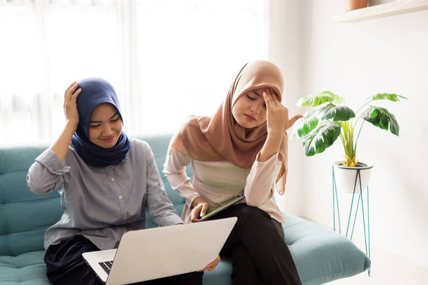 beautiful muslim woman upset business woman trying to concentrate looking at laptop monitor - Photo, Image