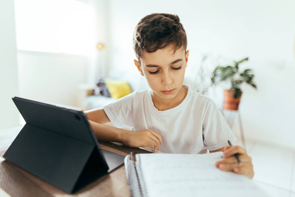 Education and technology concept - student boy with tablet computer learning at home - Zdjęcie, obraz
