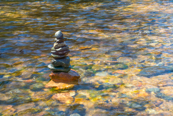 Pile of beautifully stacked stones in river - Photo, Image