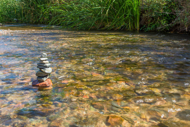Куча красиво сложенных камней в реке - Фото, изображение