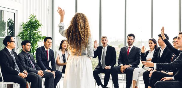 Businessman standing in front of group of people in consulting meeting conference seminar and showing hand to answer question at hall or seminar room.presentation and coaching concept - Photo, Image