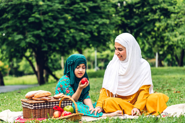 Портрет счастливой религиозной наслаждаться счастливой любовью азиатской семьи арабских мусульман мать и маленькие мусульманские девочки ребенок с хиджаб платье улыбаясь и весело моменты хорошо провести время в летнем парке - Фото, изображение