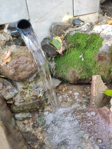 Brunnen mit klarem Trinkwasser im Wald. Ein reines, frisches Trinkwasser aus natürlicher Quelle. - Foto, Bild