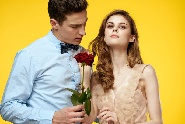 Enamored homem e mulher com rosa vermelha no fundo amarelo corte vista close-up romance - Foto, Imagem