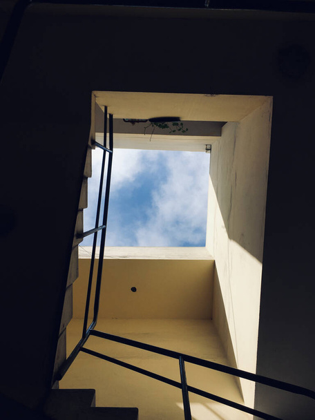 A vertical shot of a building with stairs and a view of clouds - Foto, Imagem