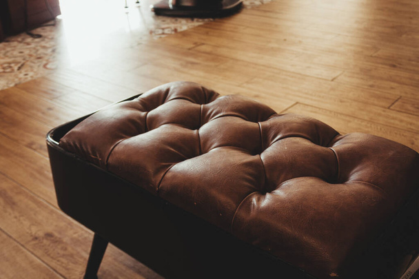 An embossed brown leather sofa on the wooden floor - Zdjęcie, obraz